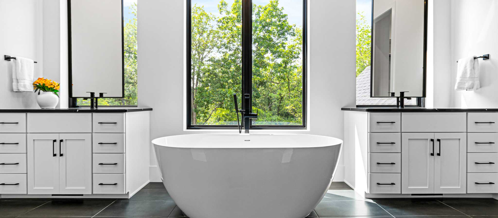 Luxurious bathroom with white cabinets and black countertops, emphasizing the sleek, modern cabinetry design.