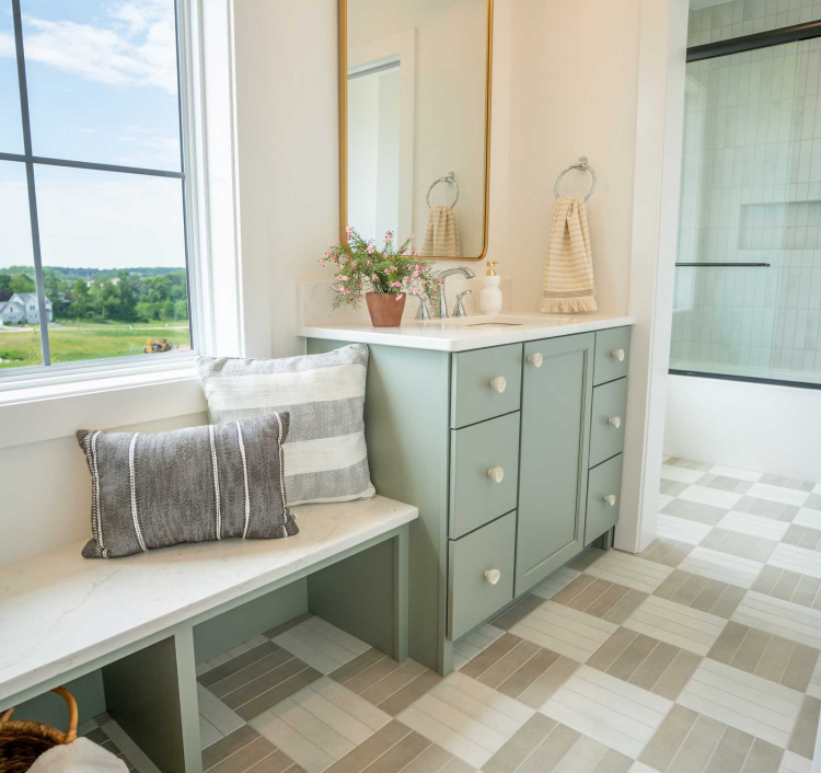 Light-filled bathroom with pale green cabinetry and spacious drawers, offering practical and stylish storage solutions.