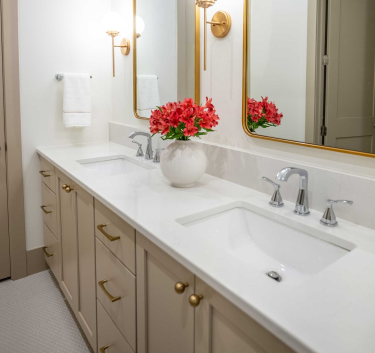 Double vanity bathroom with cream-colored cabinets and brass hardware, showcasing luxury cabinetry from StarMark Cabinetry.